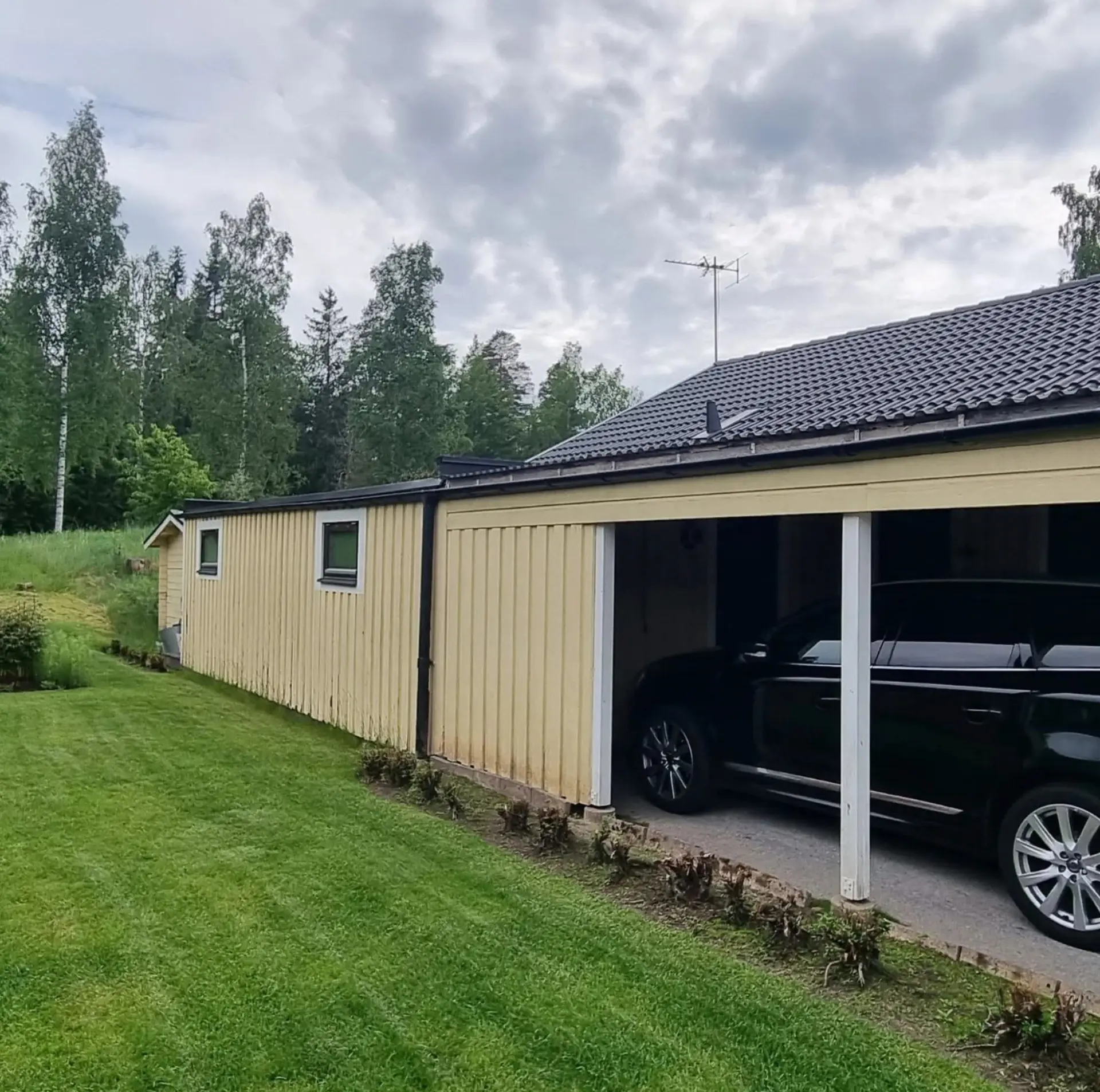 Ljusgul fasad och carport före ommålning.